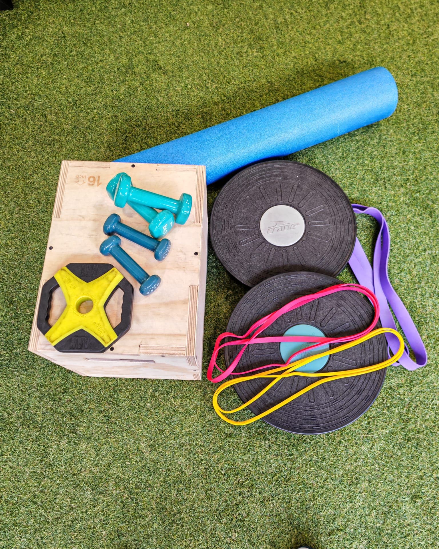 Material funcional sobre césped artificial: mancuernas, foam roller y bandas